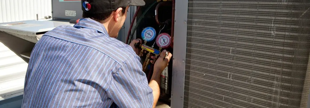 HVAC technician servicing a condenser unit in Evanston